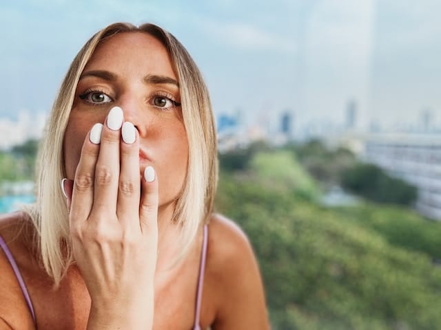 Young woman outdoors blowing a kiss, symbolizing support and compassion during ADHD Awareness Month