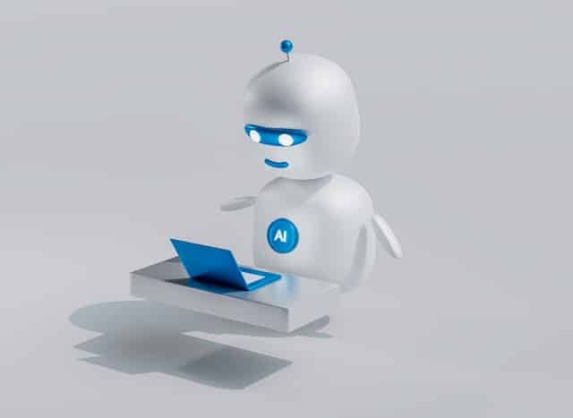 A friendly 3D illustrated robot with blue glowing eyes and an AI badge on its chest, sitting at a small blue laptop
