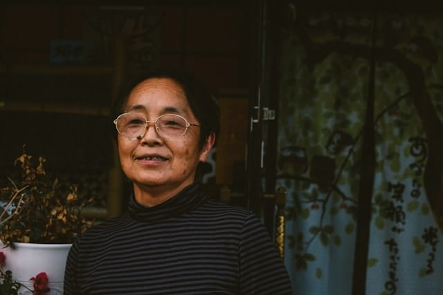 Older woman with glasses smiling warmly showing relaxed presence cultivated through Bay Area somatic therapy