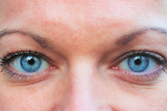 Extreme close-up of person's blue eyes with direct forward gaze showing clear eye contact
