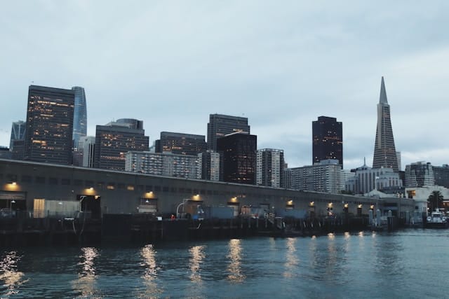 San Francisco skyline at dusk with Transamerica Pyramid and downtown buildings reflected in the bay