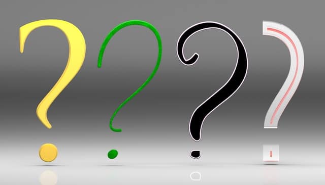 Four question marks in yellow, green, black, and white in a row